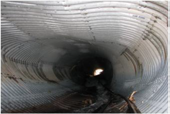 The shape of this Corrugated Metal Culvert has distorted over time due to the loss of invert, and the effect of surrounding soils on the structure.
